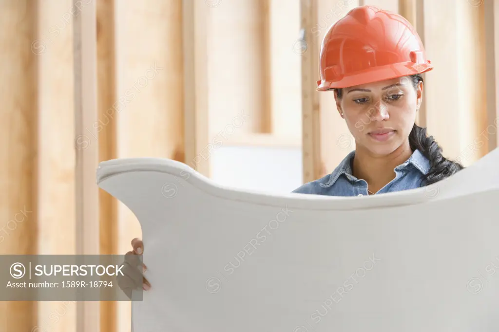 Female construction worker reading plans