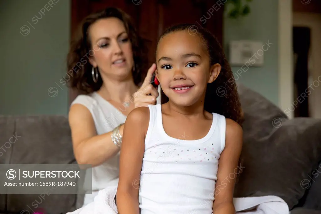 Mother fixing daughter's hair