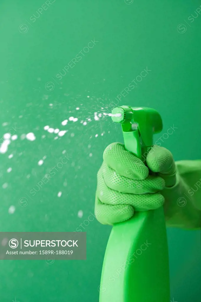 Green rubber glove squiring spray bottle
