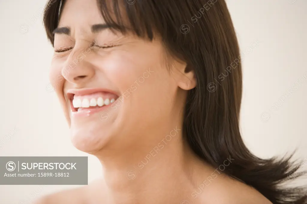 Close up of woman laughing with eyes closed
