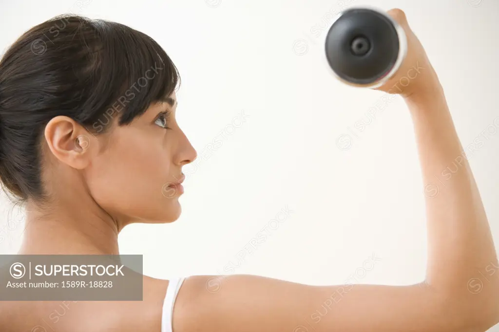 Profile of woman lifting dumbbell with arm