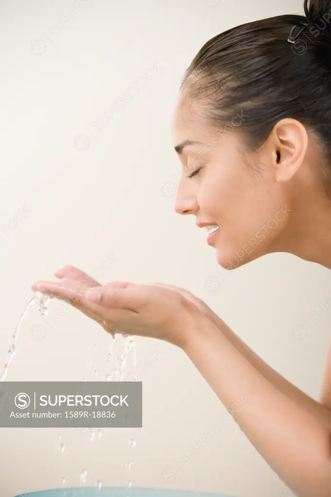 Close up profile of woman washing face