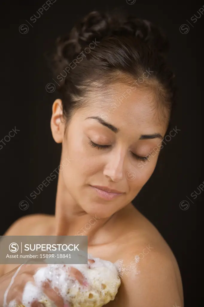 Close up of woman bathing with sponge
