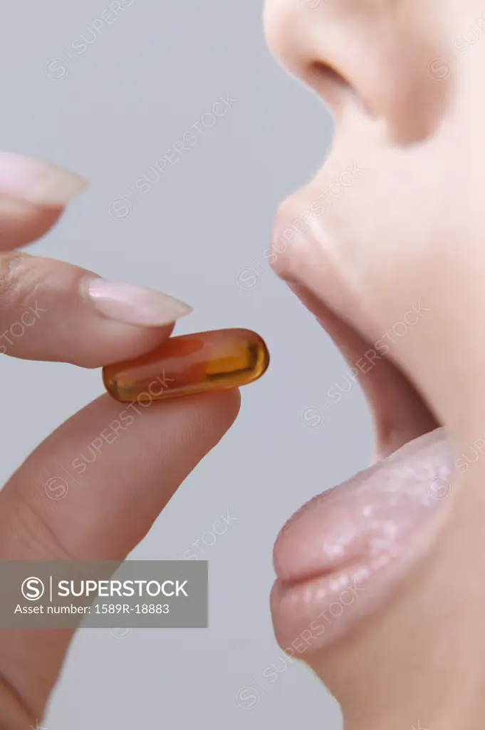 Young woman taking a pill