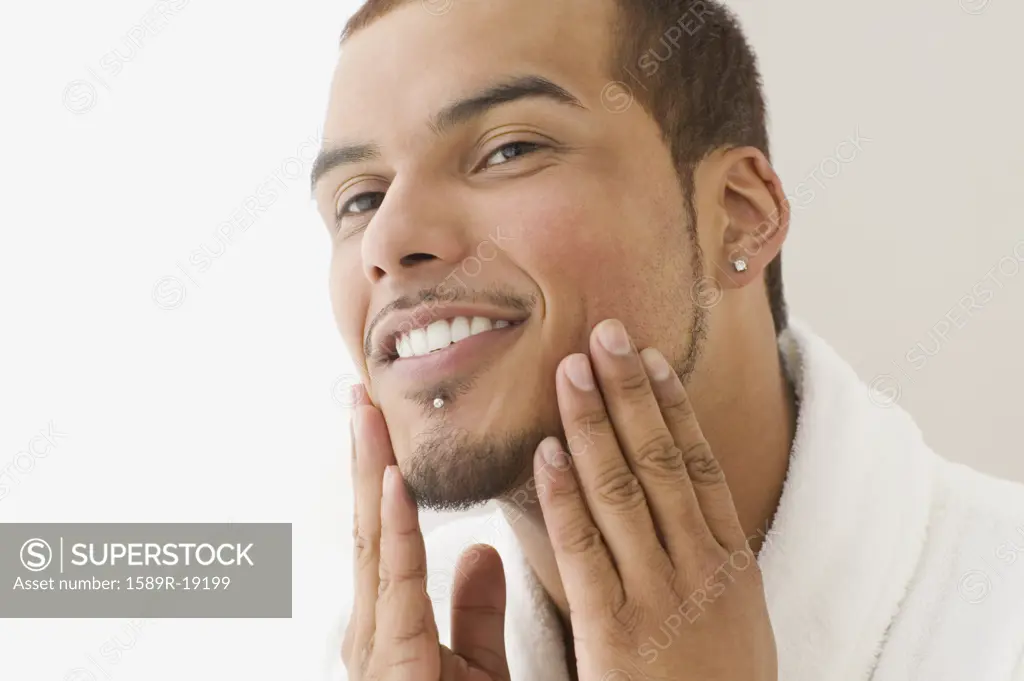 Young man rubbing his cheeks