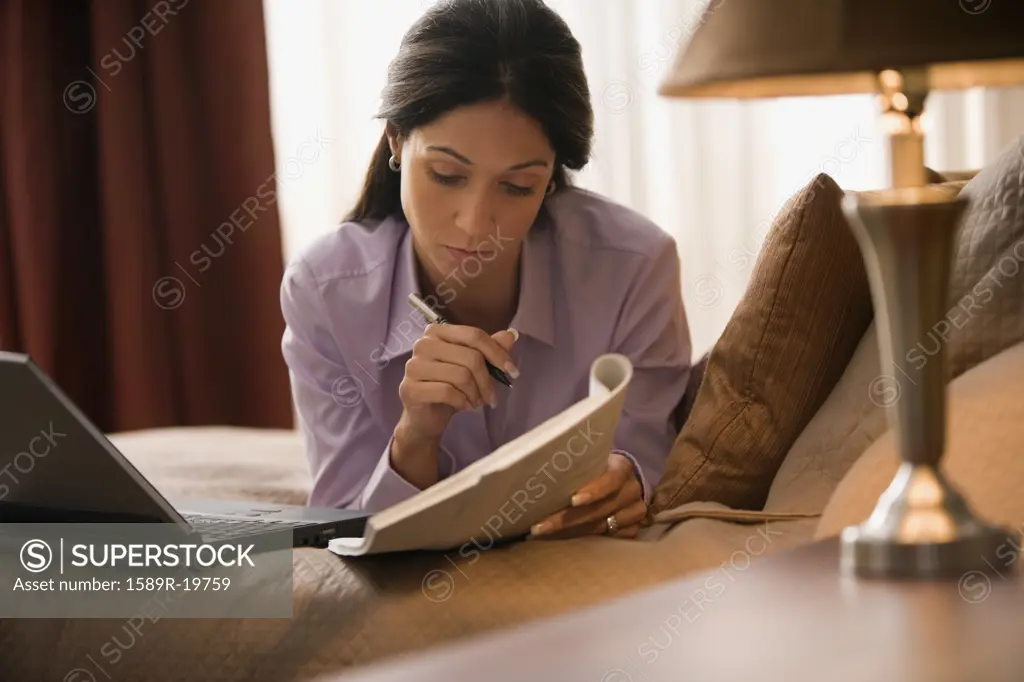 Businesswoman writing on a booklet
