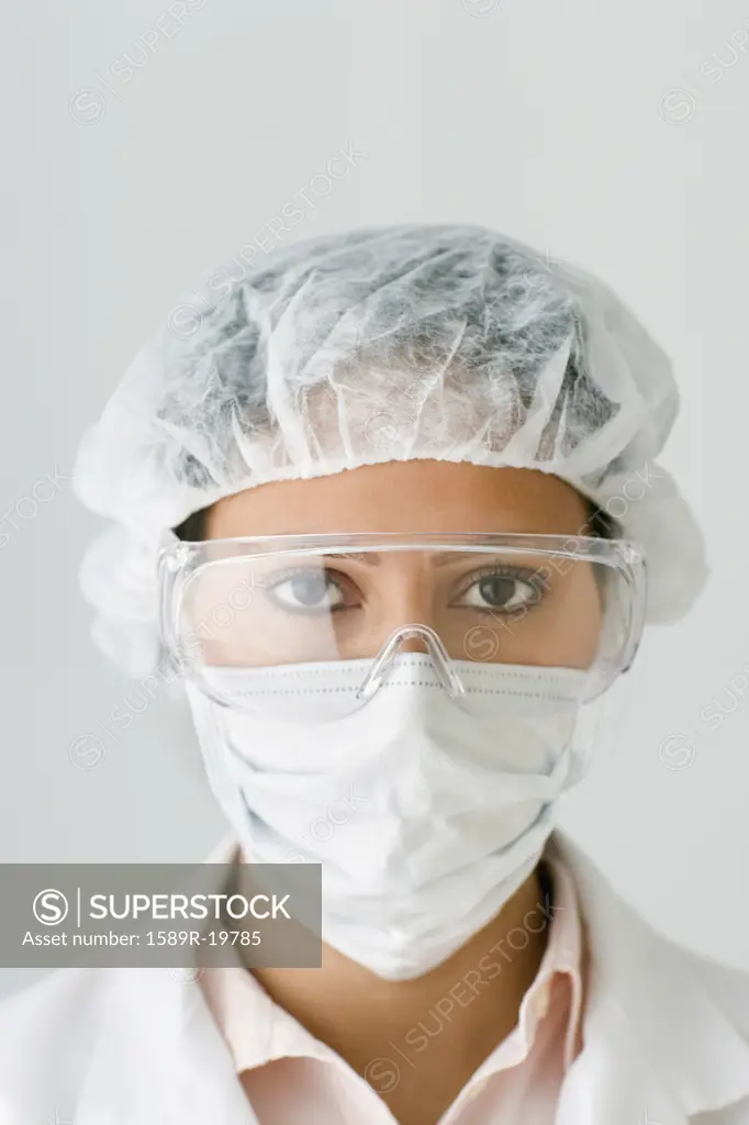 Female scientist wearing a mask, goggles and hairnet