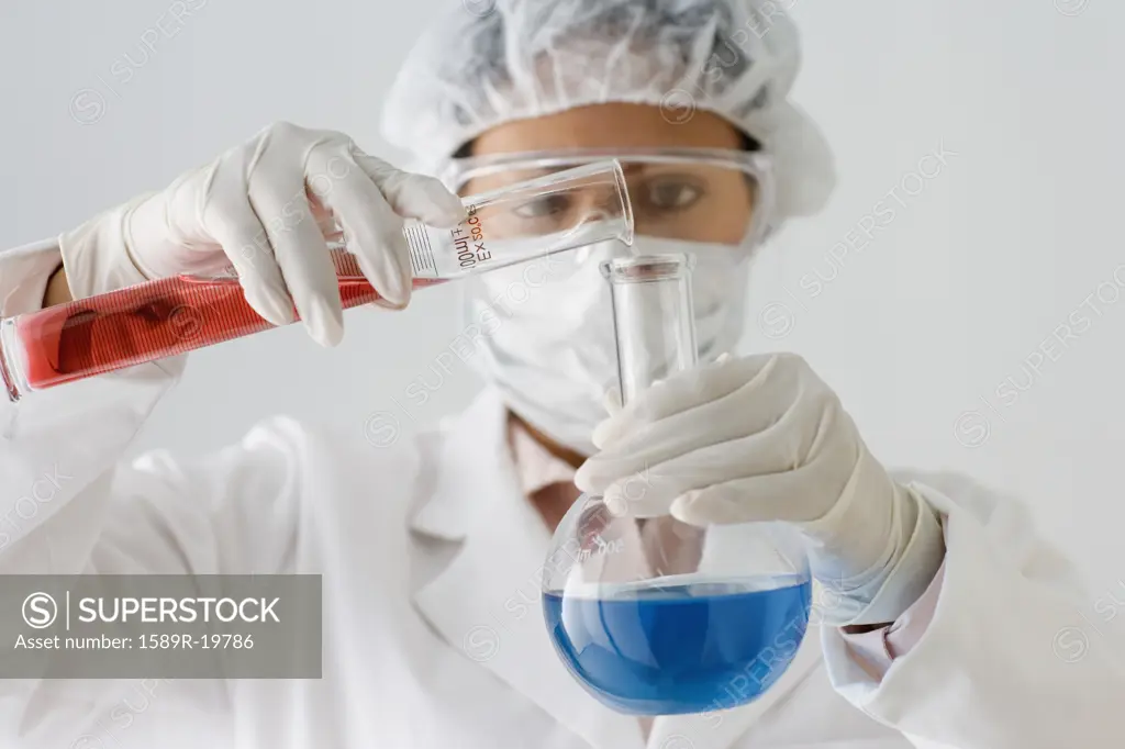 Female scientist combining chemicals