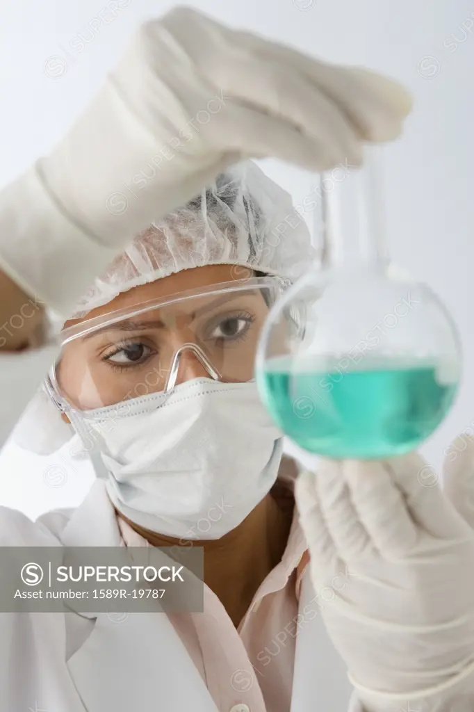 Female scientist examining beaker