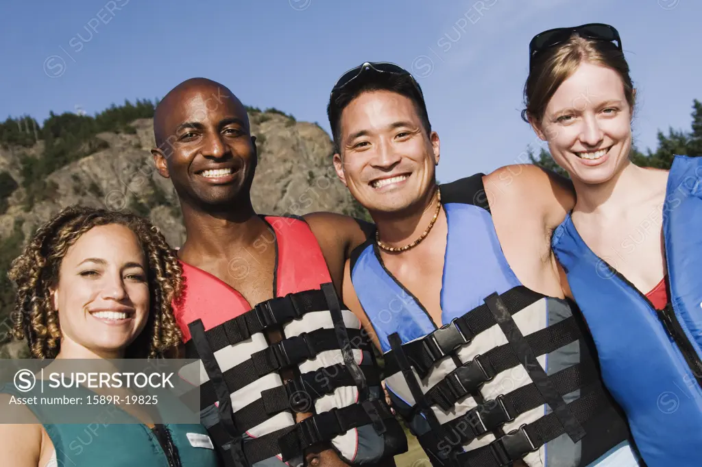 Friends smiling for the camera in lifejackets