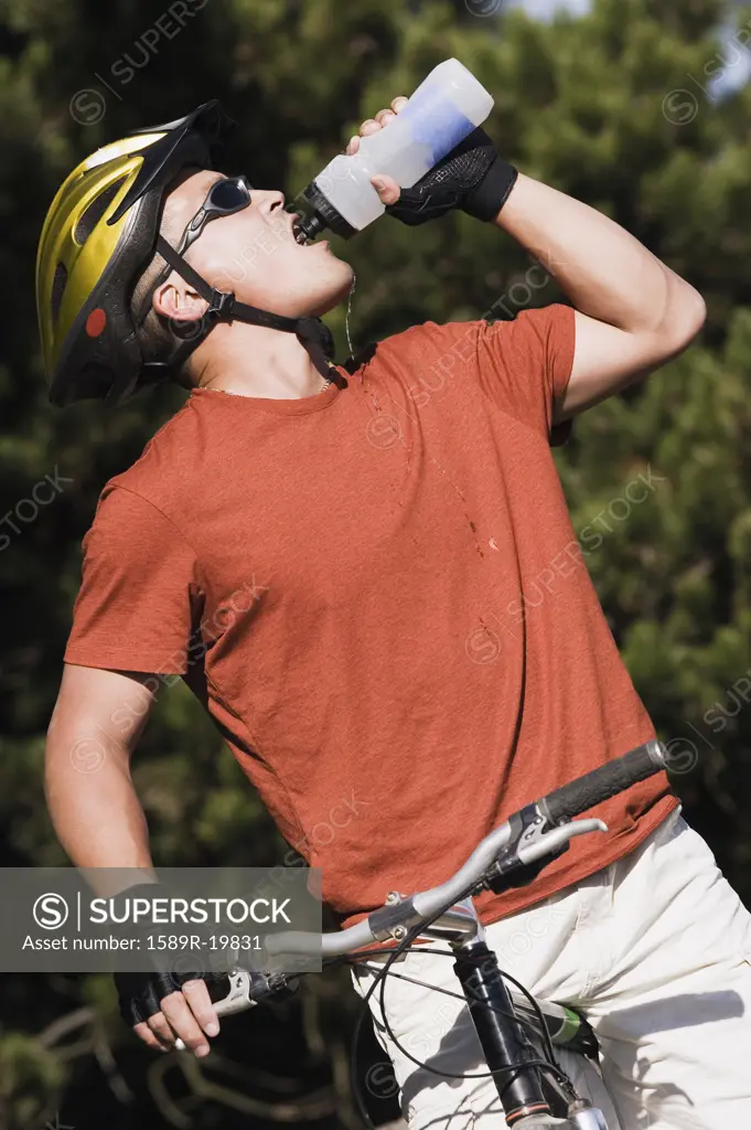 Male cyclist drinking from a water bottle