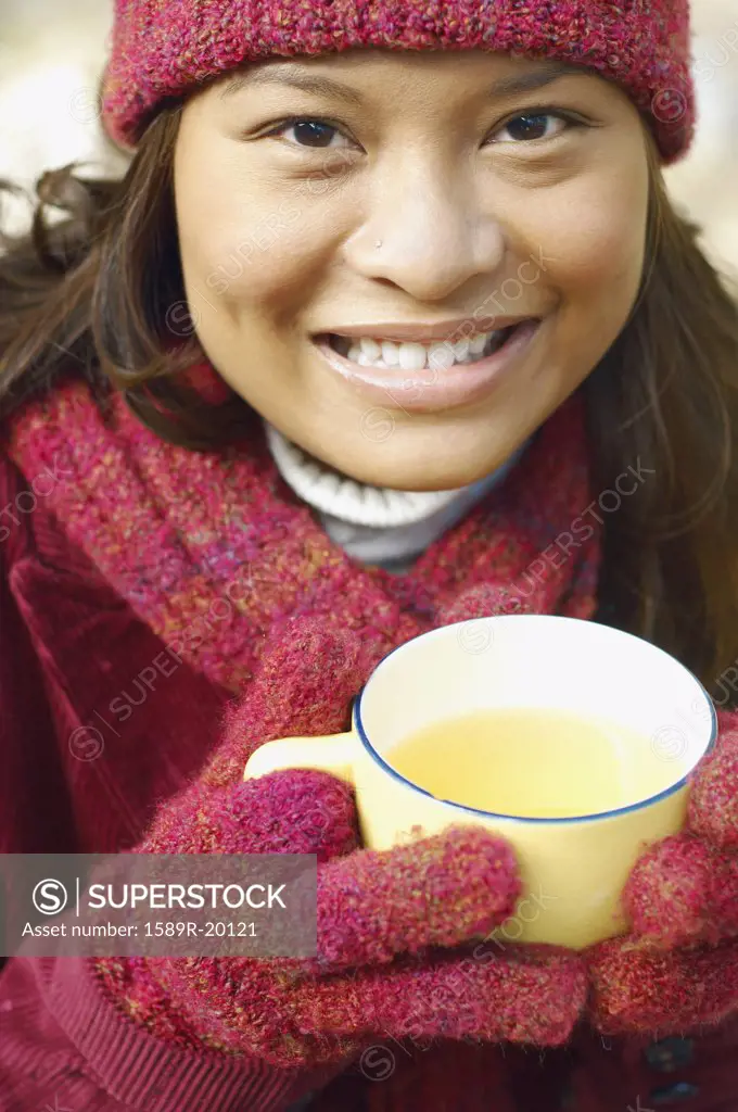 Young woman having a cup of tea outdoors