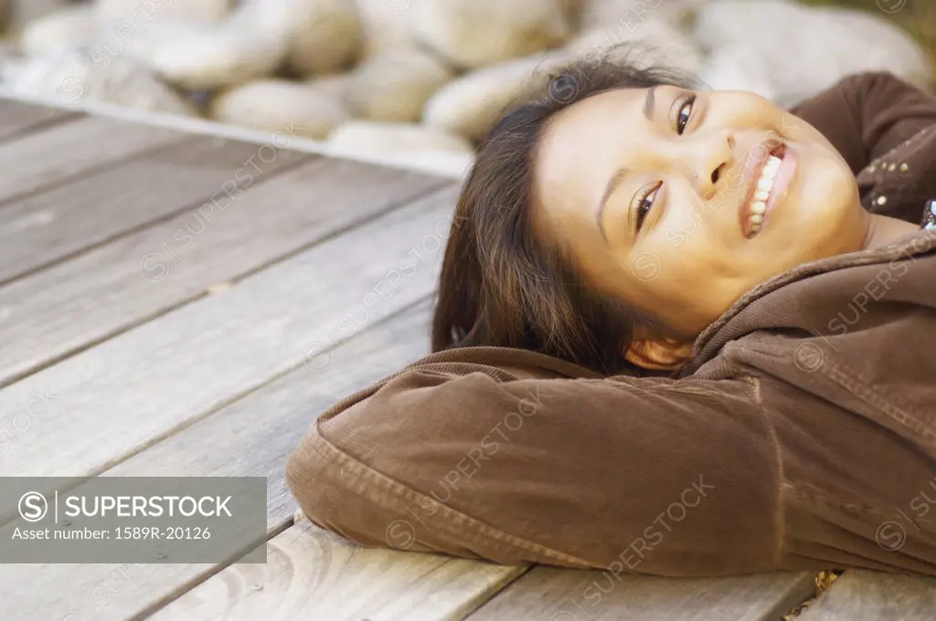 Young woman relaxing on wood deck