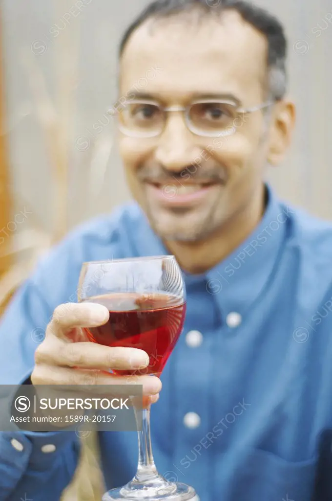 Man holding out his wine in toast