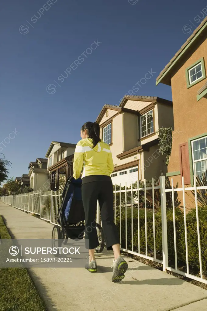 Woman walking down sidewalk with stroller