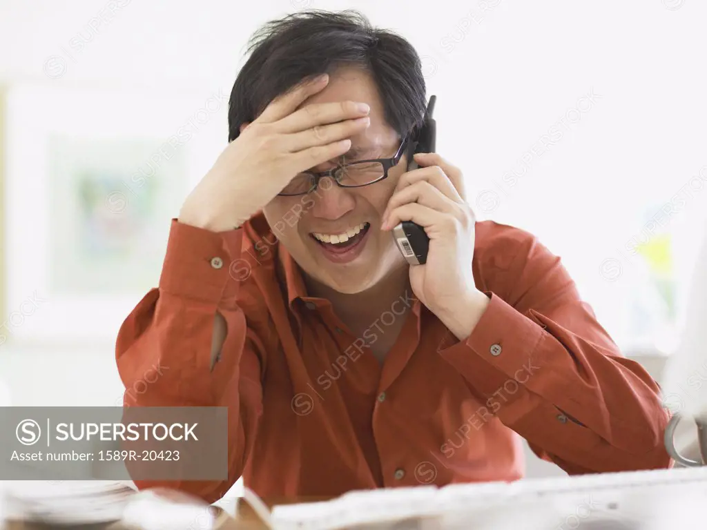 Businessman talking on the phone at his desk