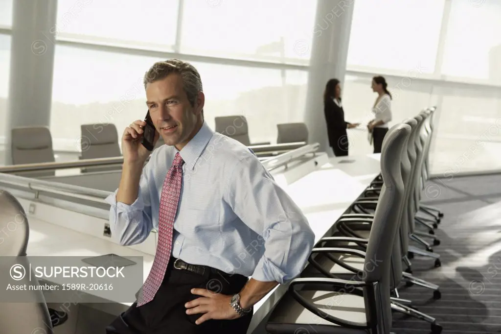 Businessman talking on cell phone in conference room