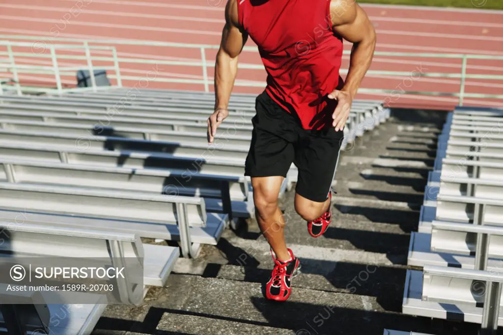 Male athlete running up steps