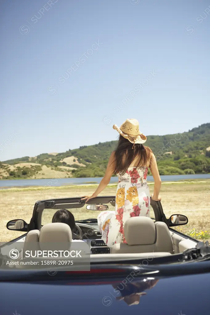Young woman standing up inside a convertible