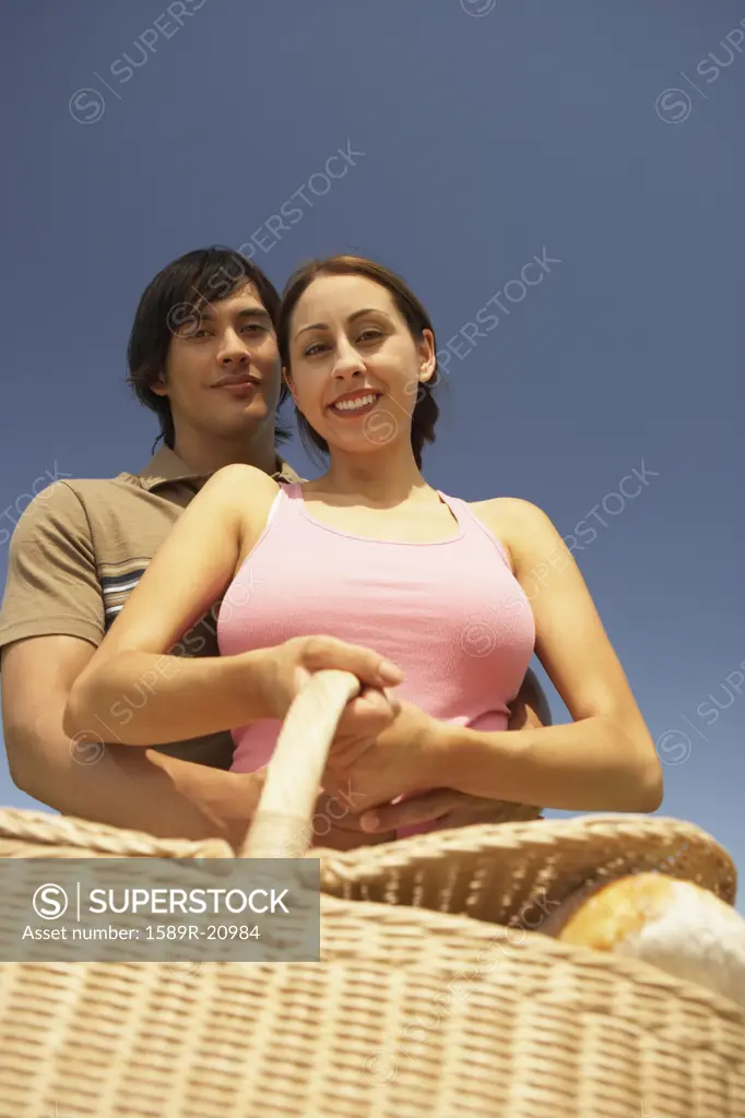 Low angle view of a couple holding a picnic basket