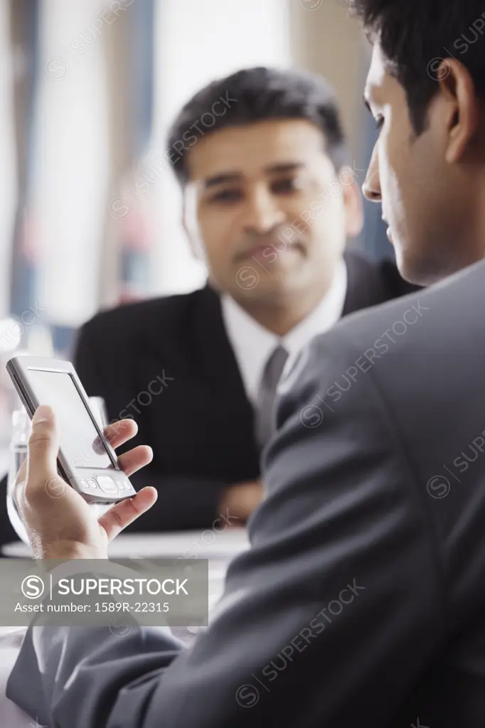 Businessman using a PDA in restaurant