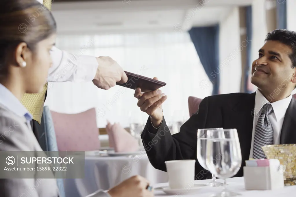 Businessman paying the check at restaurant
