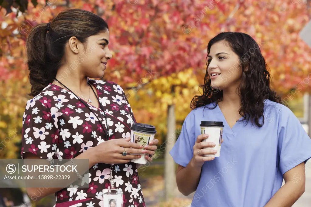 Young nurses having coffee outdoors