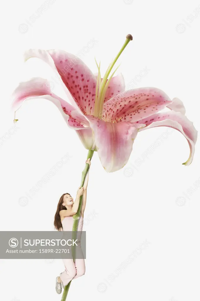 Young woman climbing a giant orchid