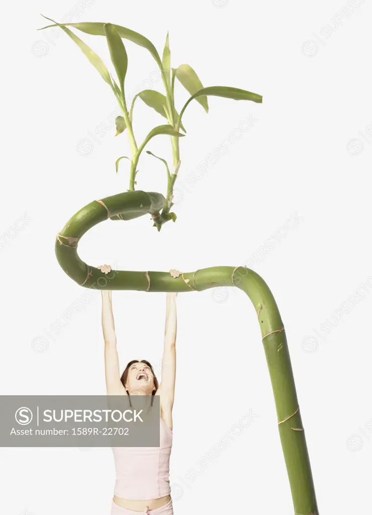 Young woman climbing a giant plant