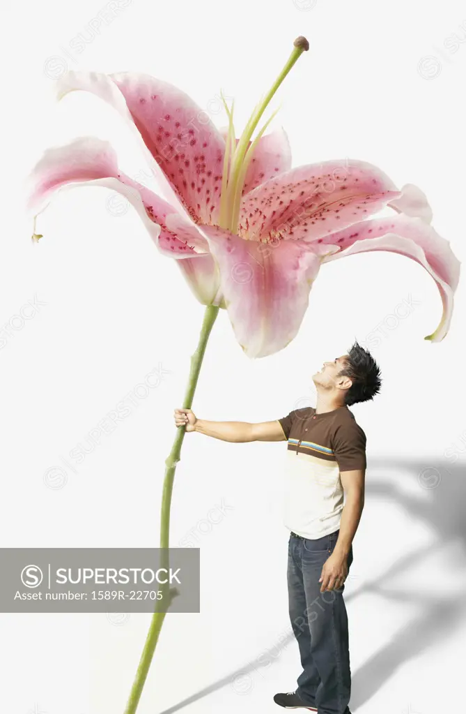 Young man holding a giant orchid