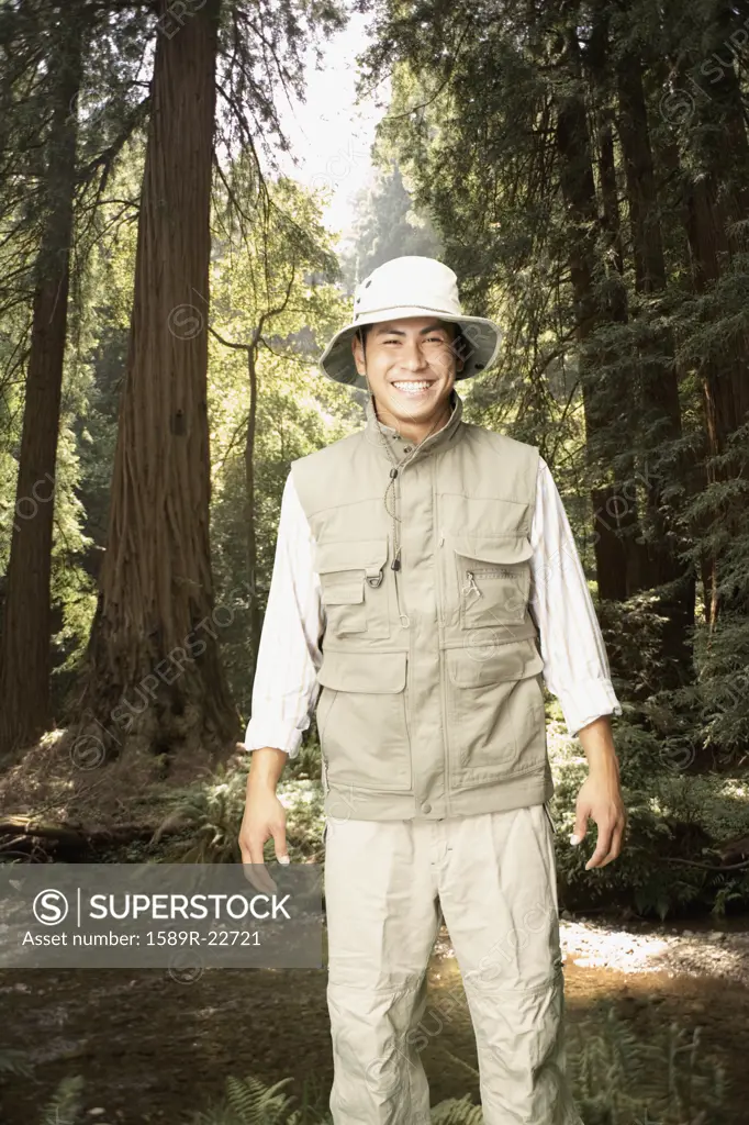 Explorer smiling in forested area
