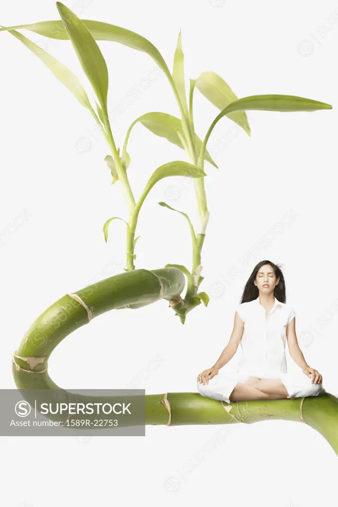 Young woman meditating on a giant plant