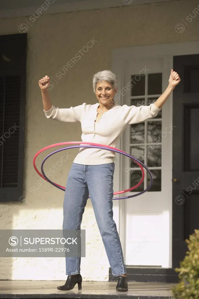 Hispanic grandmother playing with hula hoops on the porch, Richmond, Virginia, United States