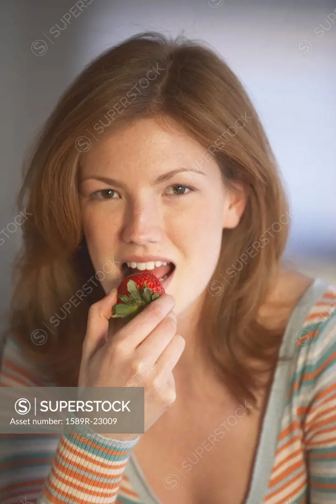 Young woman eating a strawberry, Richmond, Virginia, United States