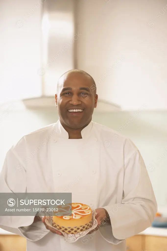 African male pastry chef holding a cake, Richmond, Virginia, United States