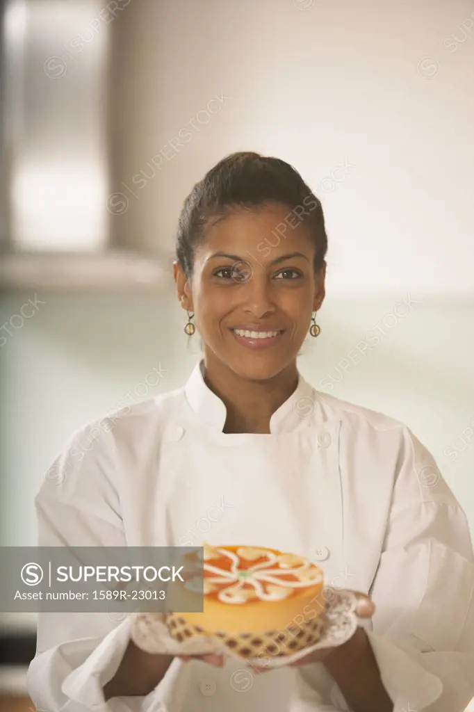 African female pastry chef holding a cake, Richmond, Virginia, United States