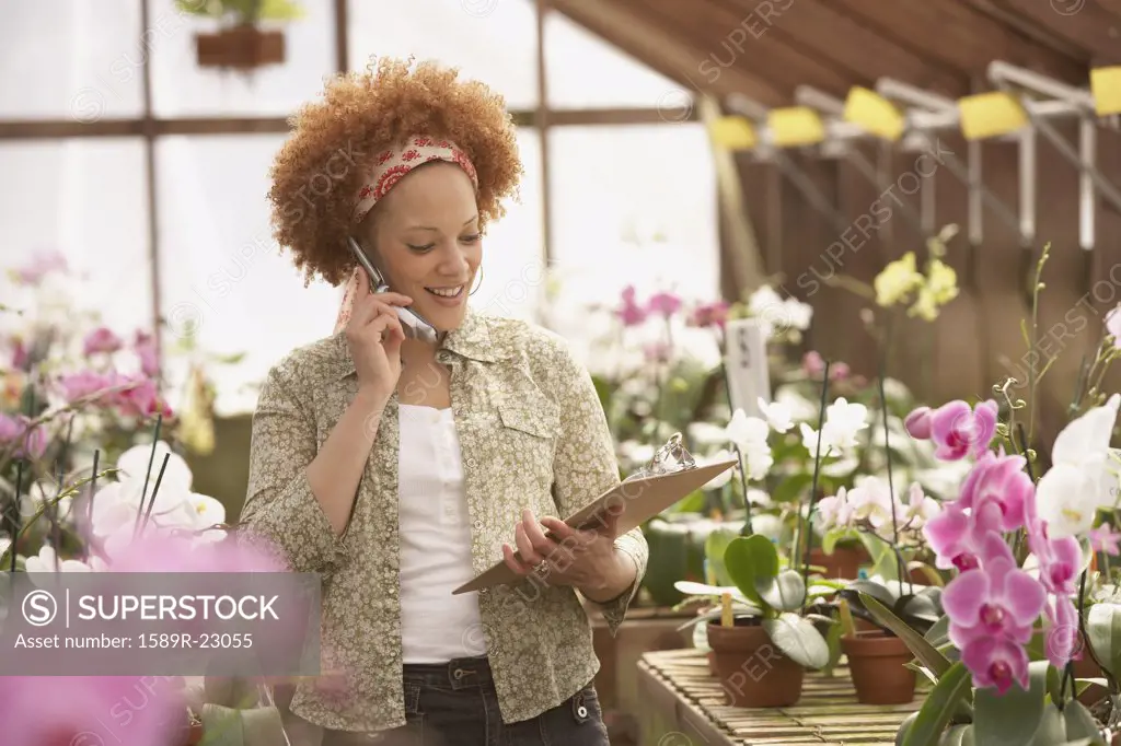 African American woman on cell phone in greenhouse