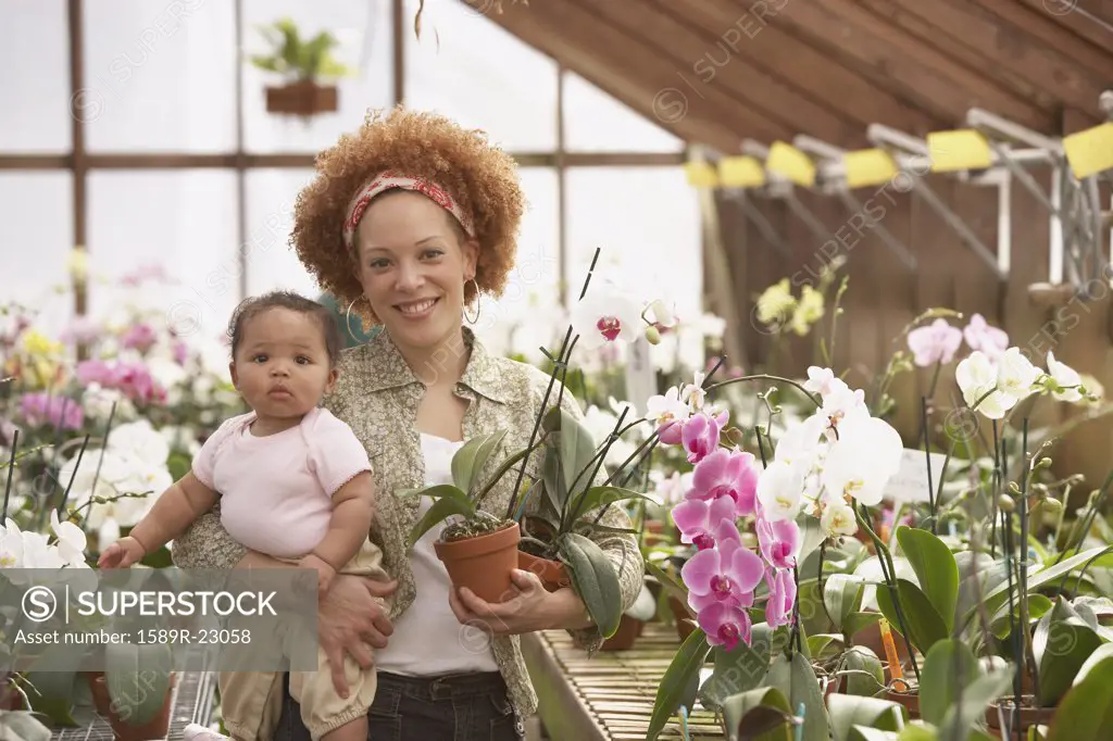 African American mother with baby in greenhouse