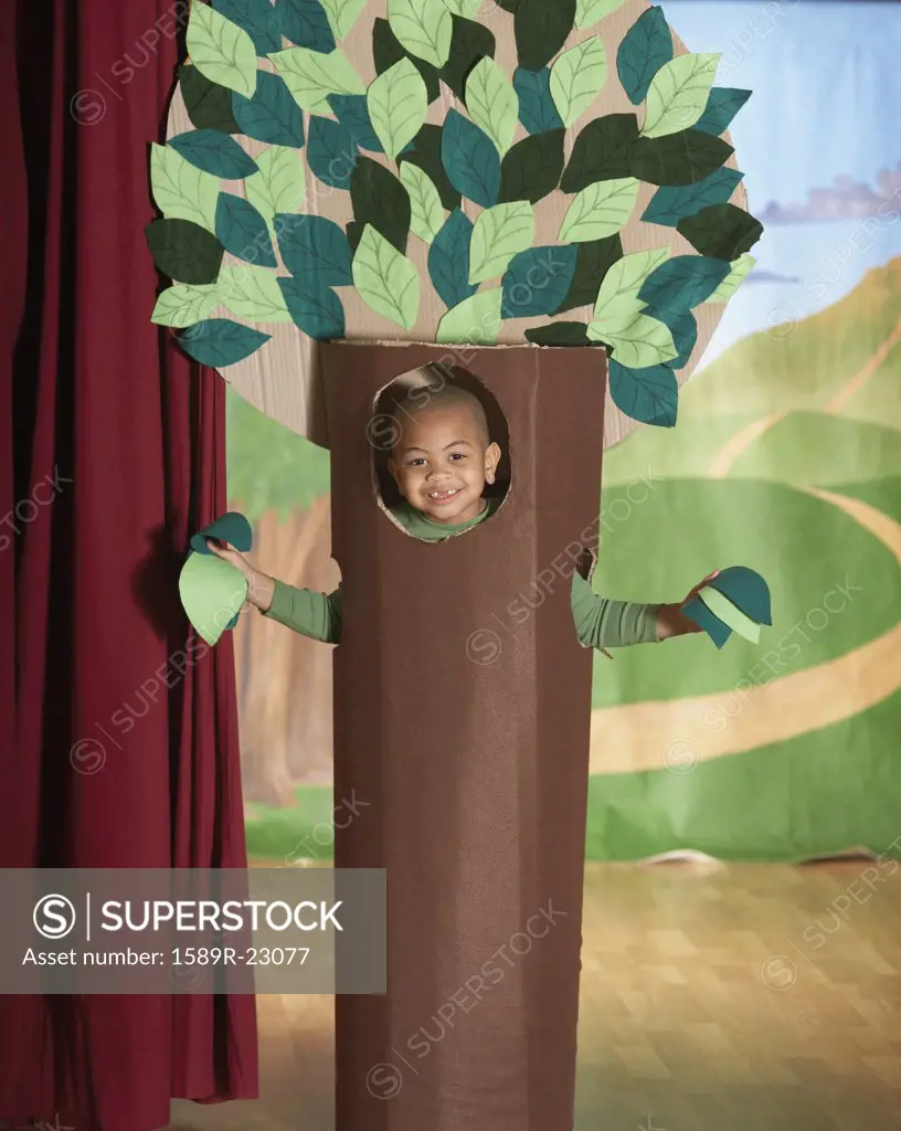 Young African American boy in tree costume on stage