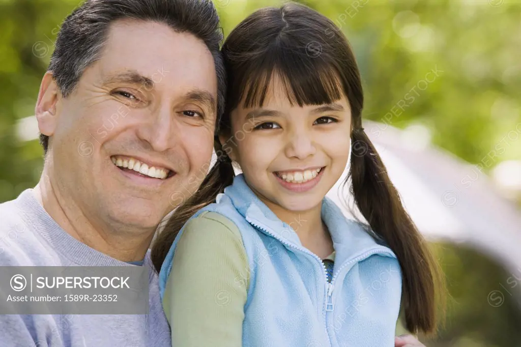 Hispanic father and daughter smiling