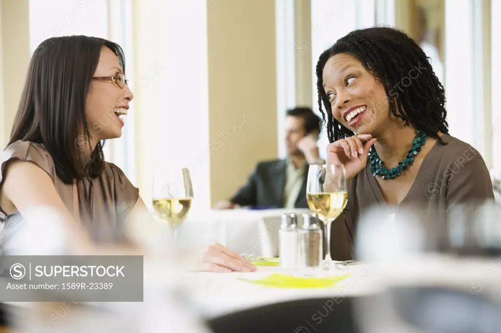 Two businesswomen laughing in restaurant