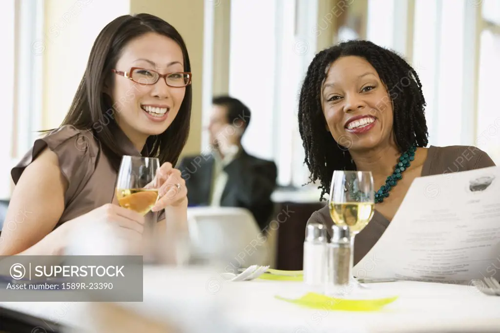 Two businesswomen smiling in restaurant