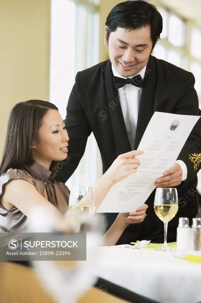 Asian businesswoman ordering meal in restaurant