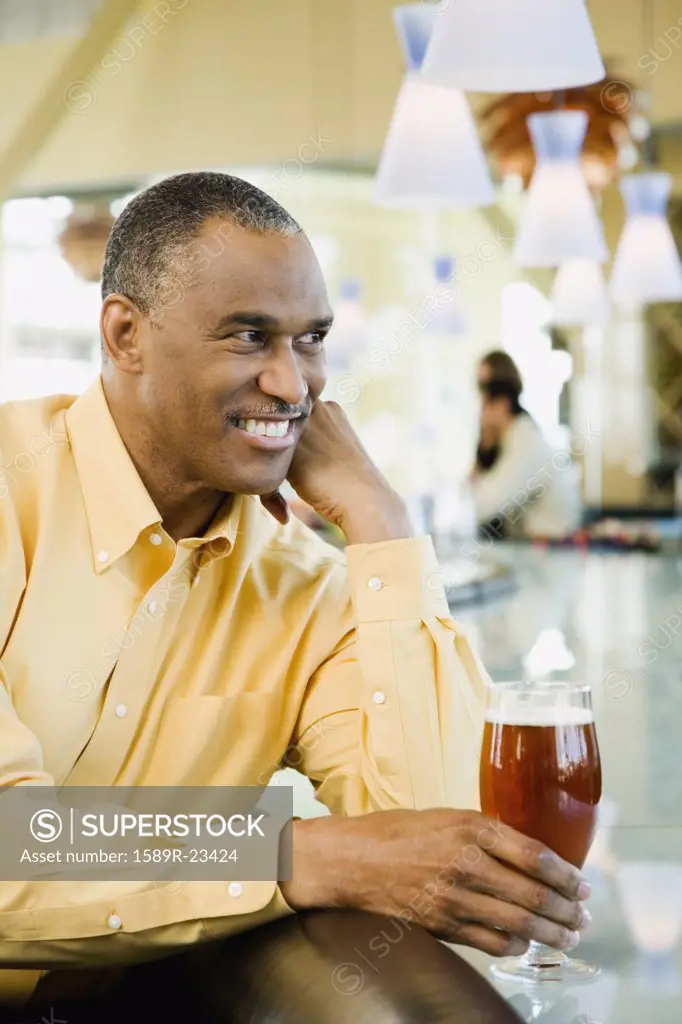 African American man with drink at bar