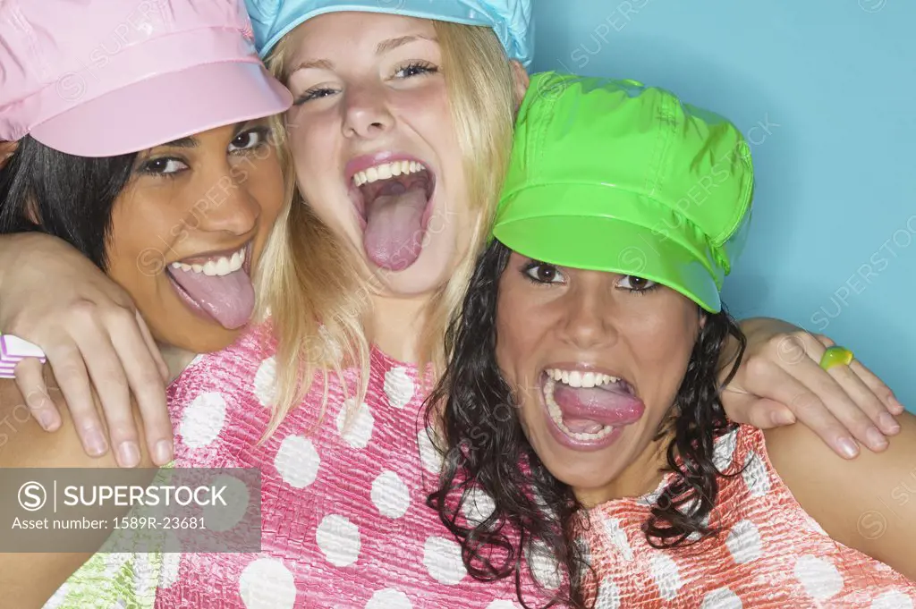 Three young women laughing and sticking their tongues out