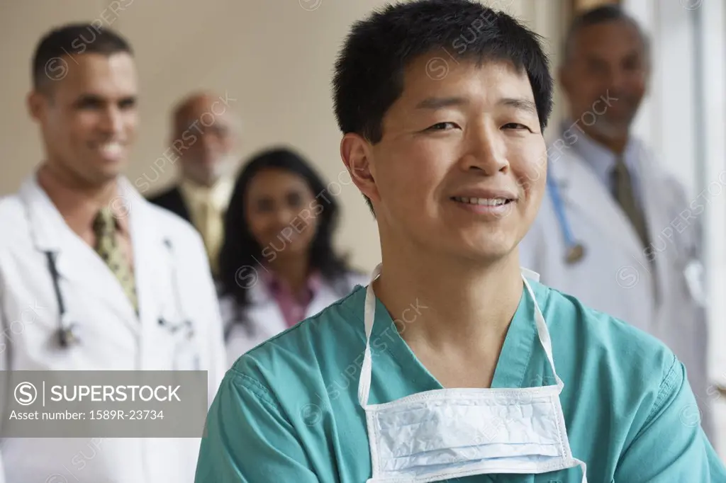 Male Asian surgeon with co-workers in the background