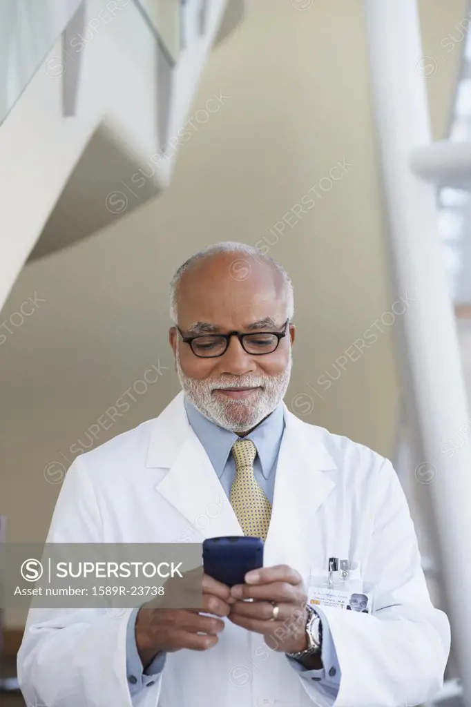 Senior male African doctor using electronic organizer