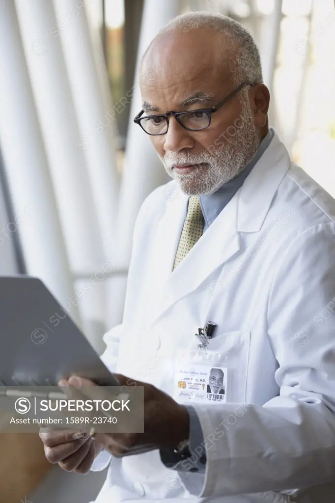 Senior male African doctor reading chart