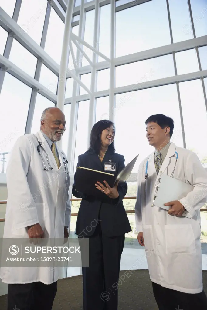 Businesswoman talking to two male doctors, North Bethesda, Maryland, United States