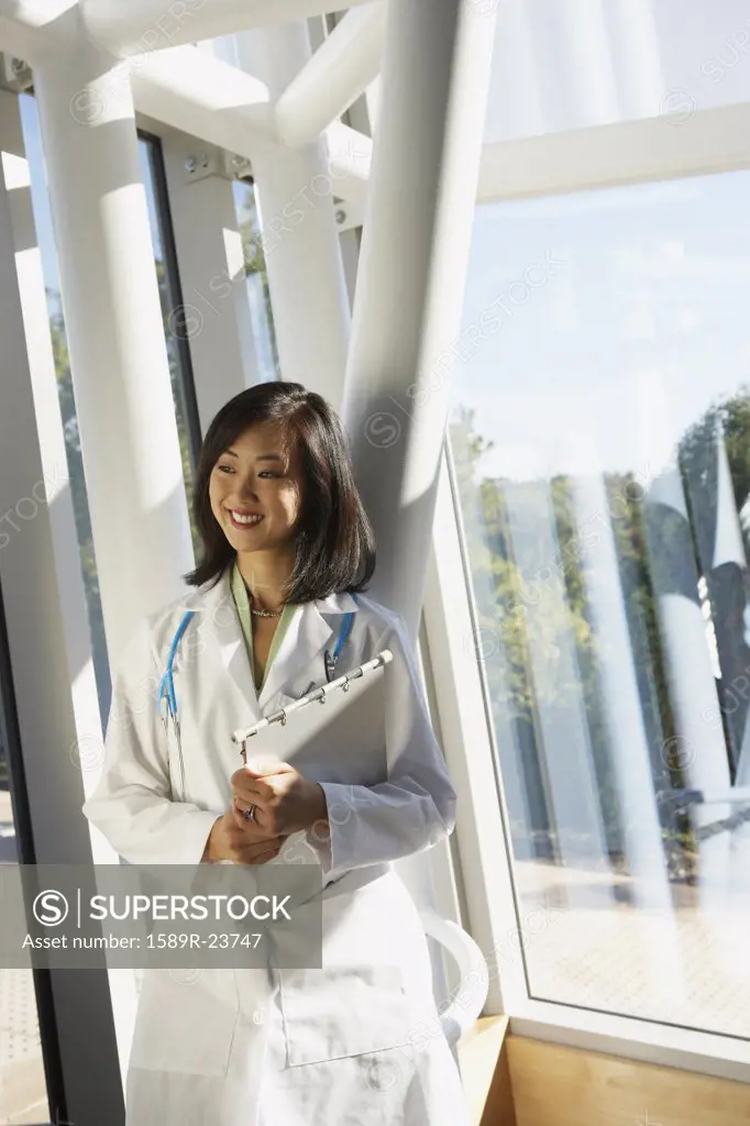 Young female Asian doctor standing next to window, North Bethesda, Maryland, United States
